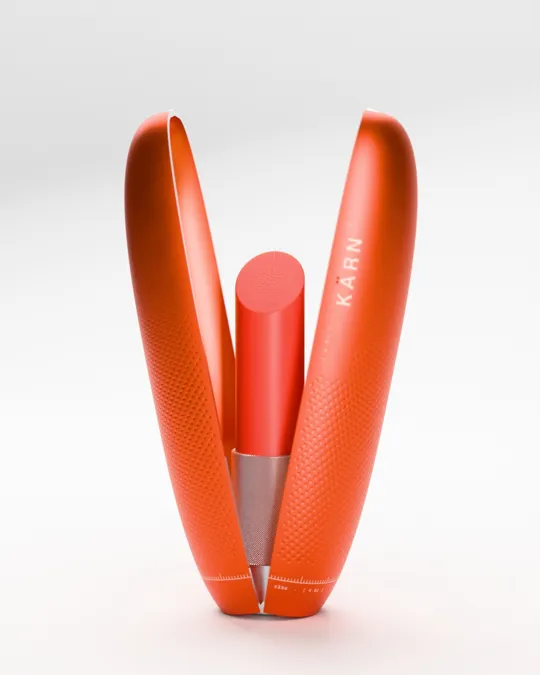 The KÄRN seed pod open, tangerine satin anodised aluminium, the lipstick rising inside